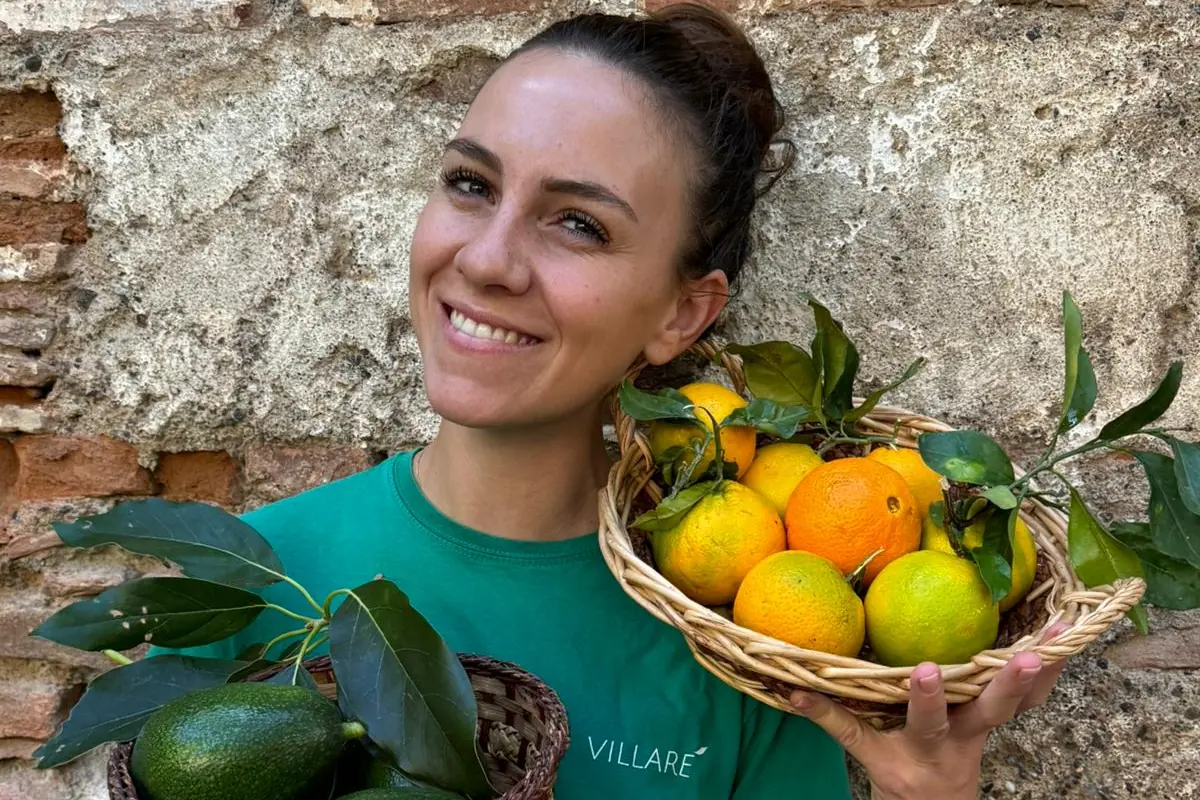 Marzia Villari con cestini di agrumi e avocado coltivati a Villarè